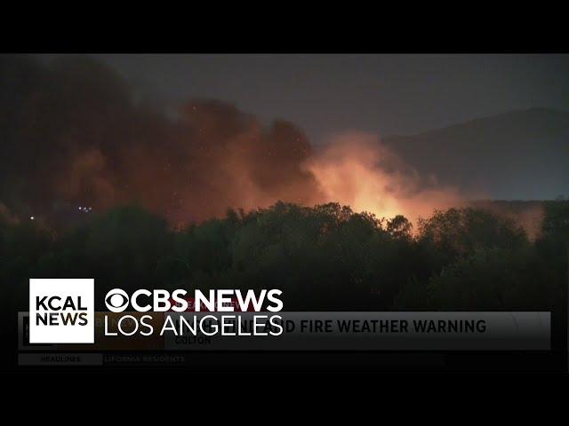 Firefighters work to put out Colton brushfire as winds hit the area