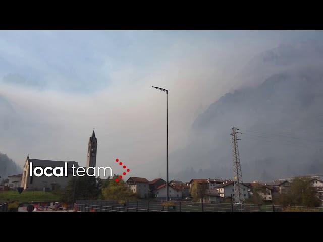 Taibon Agordino completamente immersa nel fumo dell'incendio