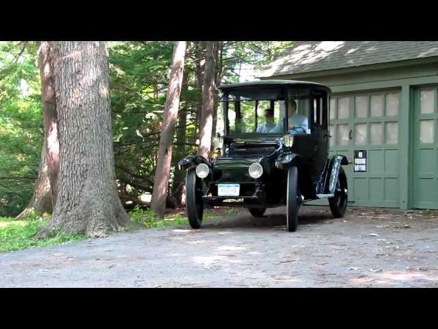 1914 Detroit Electric car drives silently away from its garage