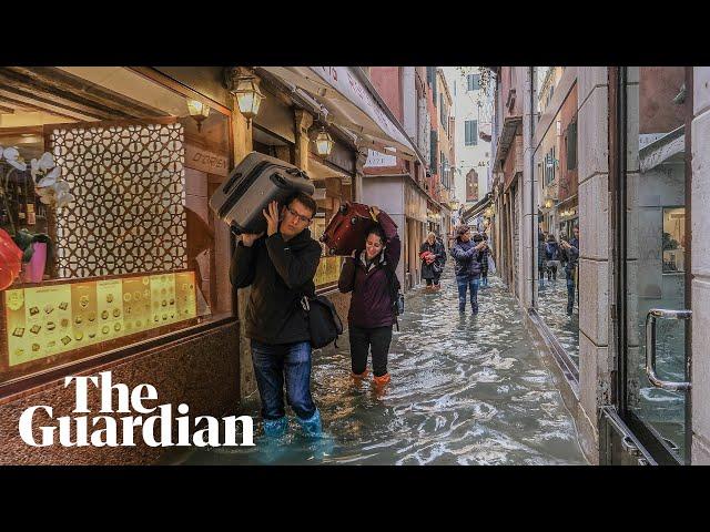 Venice: Tourists and residents wade through flood waters