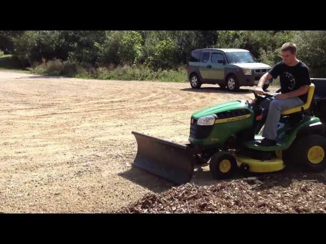 Deere D130 riding mower using Nordic Plow in summer