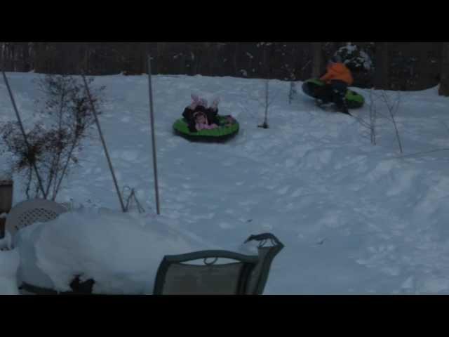 Kids sledding down a small hill