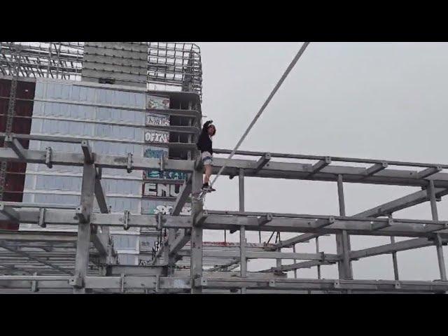 Man tightropes between DTLA graffiti towers