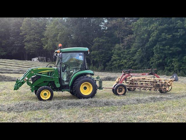 John Deere 3039R and New Holland 256 raking hay