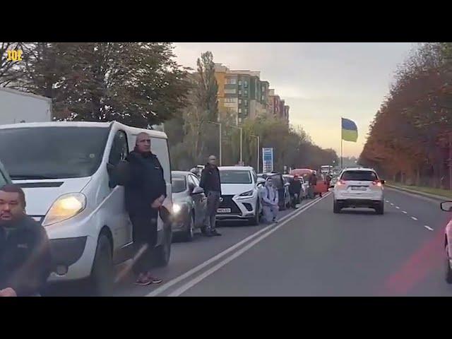 Ukrainians kneel on road as their fallen heroes return home