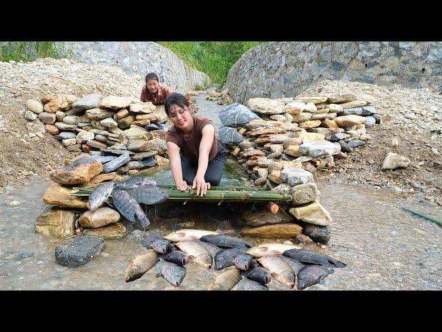 Single girl and her friend create a unique fish trap using rocks, a natural way to catch fish