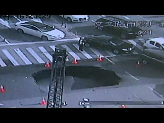 Sinkhole opens in busy road, quick-thinking cop averts tragedy, China