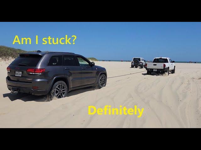 Jeeps stuck, Toyotas stuck, and a Land Rover stuck at the beach.