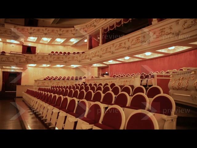 An empty hall in the theater: rows of chairs and beautiful ornaments