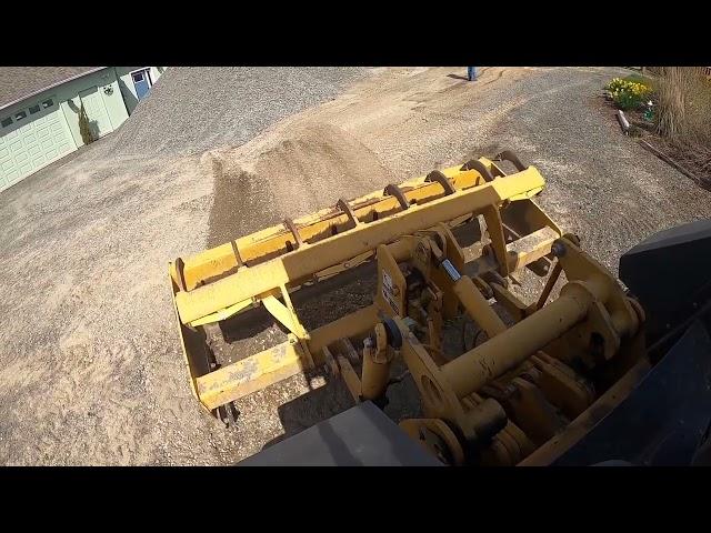 Spreading rock with the John Deere 210K skiploader