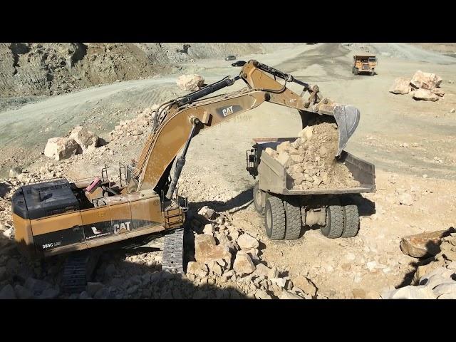 Caterpillar 385C Excavator Loading Rocks On Dumpers - Labrianidis SA