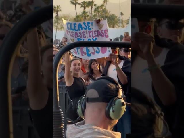 Emma Chamberlain holding a "Please play Espresso" sign during Sabrina Carpenter's Coachella set (W2)