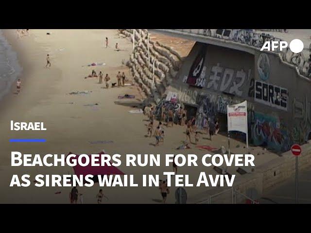 Beachgoers run to take shelter as sirens wail in Tel Aviv | AFP