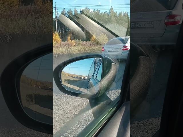 Водитель серой Лады обгоняет поток по обочине, разносит пыль
