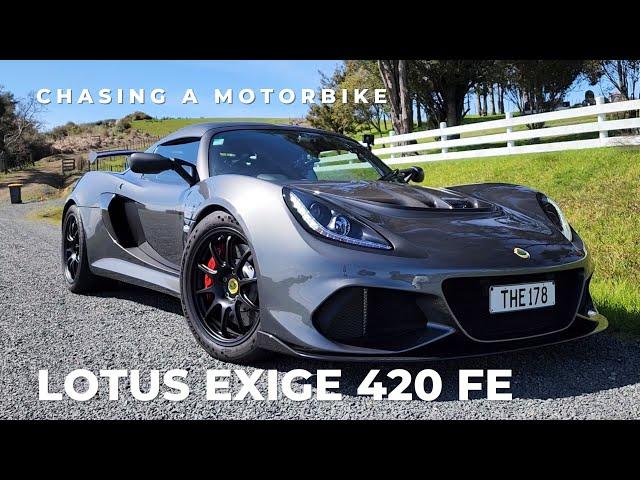 Lotus Exige 420 FE chasing a motorbike on a twisty backroad