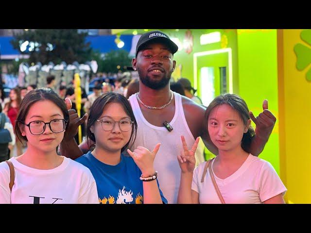 Black guy walking in China, Chinese girls surprised and want to take pictures with him.