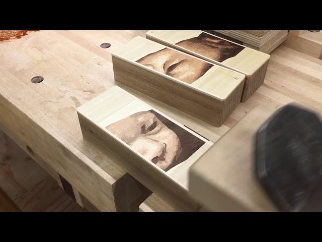 Hand-planing a picture made of wood.