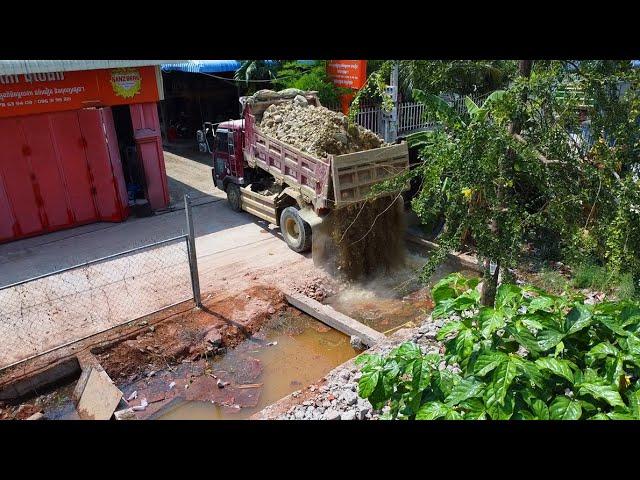 Casting stones to delete ancient pits in house fences use KOMATSU D20P dozer with dump truck unload