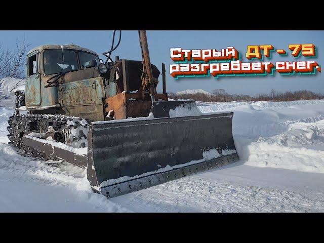 Старый  ДТ 75 разгребает снег.