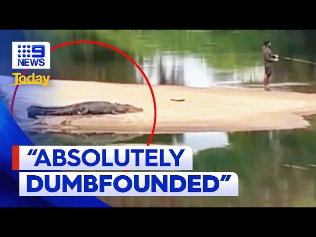 Footage of man fishing metres away from crocodile in Cairns | 9 News Australia