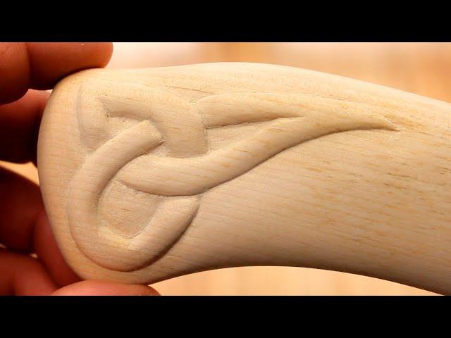 Simple wood carving.  Scandinavian ornament on the handle of an ax