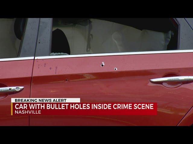 Car with bullet holes inside crime scene