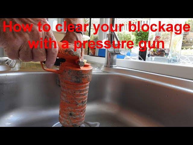 Clearing blocked waste pipes with a pressure gun