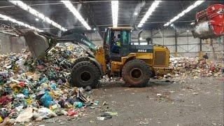 Operator pushing a waste with a front and loader  at refusse tranfer station// CCT