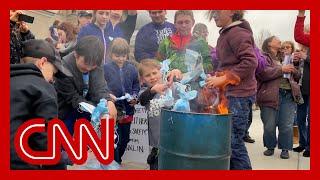 Children burn masks at rally