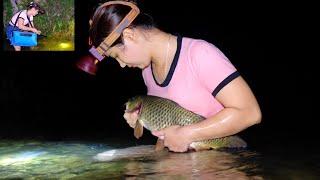Late at night the girl caught a giant fish in the river with her bare hands