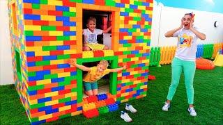 Vlad und Niki spielen mit farbigen Spielzeugblöcken und bauen ein dreistufiges Haus
