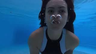 Girl swimming underwater with puffy cheeks