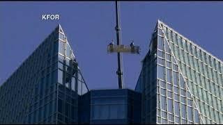 Window washers trapped in basket swinging at top of tower