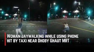 Woman jaywalking while using phone hit by taxi near Dhoby Ghaut MRT