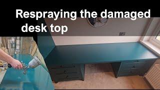 Respraying the damaged desk top with PU enamel paint.
