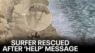 Kite surfer rescued after spelling out 'Help' in sand