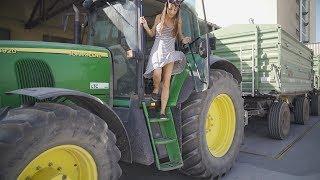 Farmer girl takes the harvest with the John Deere to the warehouse