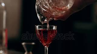 stock footage classic bartender pouring liquor from a tall glass to a cocktail glass in interior cla