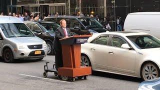 Melissa McCarthy as Sean Spicer podiums on a NYC street, May 12, 2017