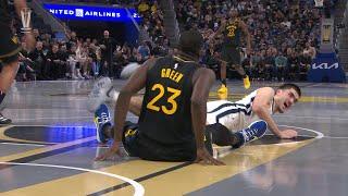 Draymond Green hooks Zach Edey's leg under his arm 