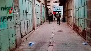 Israeli settlers throw stones from the roof of a settlement towards Palestinians in Hebron