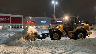 John deere 544K plowing snow in a parking lot