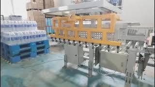 Film wrapped water palletizing, palletizing robot be mineral bottled water neatly on the pallet.