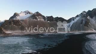 Aerial view landing on the Stokksnes black sand beach, winter sunset in Iceland