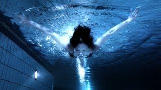 Beautiful midnight swimmer underwater in pool at night