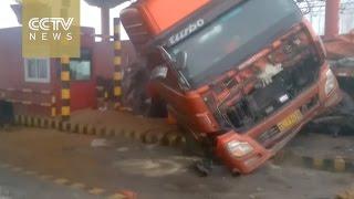 Semi-trailer slides off slippery road, smashes into toll booth