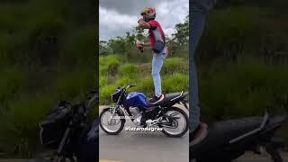 Lázaro Du grau andando em pé na moto e tomando uma coca cola