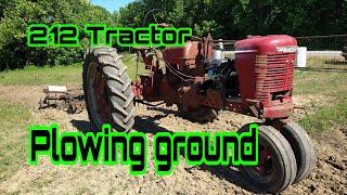 Predator 212 Tractor plowing ground. 6.5 horsepower full size tractor pulling a disc.