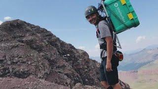 Chase Harr carries a Shelterbox to the summit of New England's 67 4000 footers