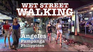 Rainy Saturday Night in Angeles city. Wet Walking Street.